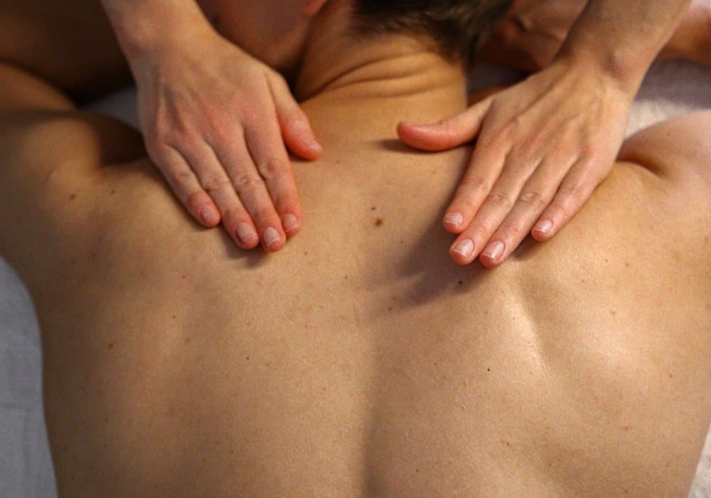 Massage du dos, les deux mains posées de part et d'autre de la colonne